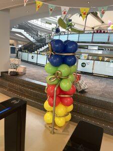 Ballonstaander pakjes met gekleurde pakjes blauw, groen, rood en geel met een goud strikje Ballonstaander pakjes met gekleurde pakjes blauw, groen, rood en geel met een goud strikje